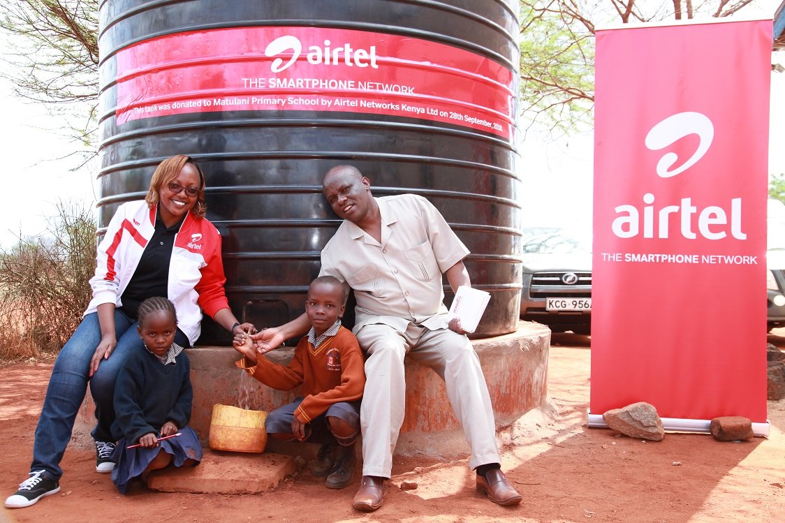 Airtel’s Senior Communication and CSR Executive, Marion Wambua with pupils and the head teacher of St. Michael Matulani Primary, Mr. Japheth Kyangu during the donation of the water at the school in Mtito Andei.