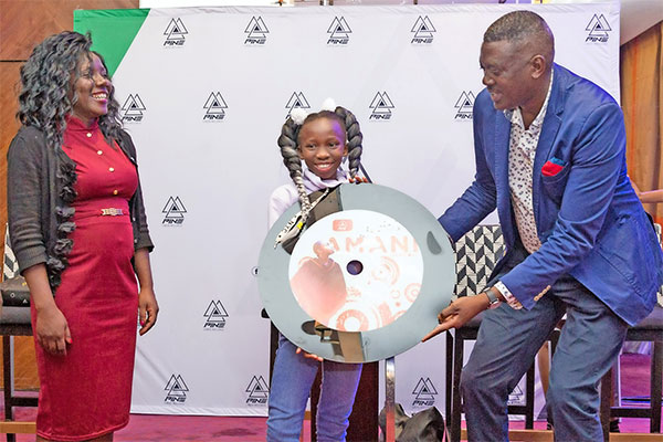 Pine Creek Records Founder Mr. Peter Nduati hands Amani G her record as her mother Christine Ambuso looks on